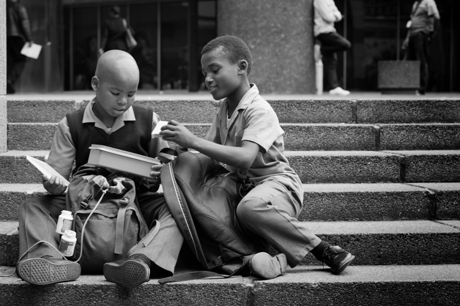 Boys share their lunch on Thibault Square in Cape Town